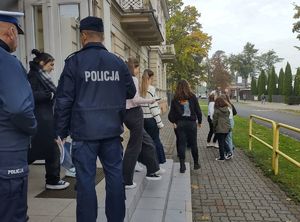 policjanci pokazują drogę ewakuacji