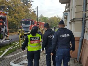 dowódca z policjantami wchodzi na teren szkoły