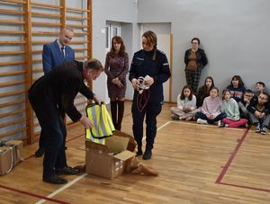 dyrektor wyciąga odbaski i przekazuje je policjantce