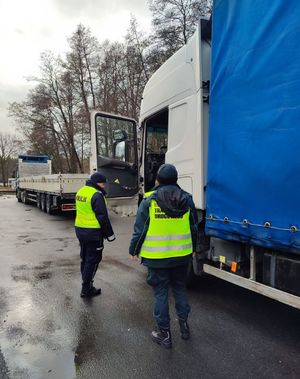 policjant z ITD stoją przy pojeździe ciężarowym