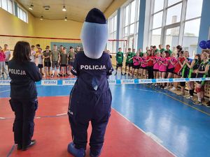 polfinek i policjantka rozpoczynają turniej, stoją przed młodzieżą
