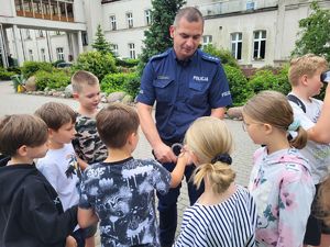 policjant pokazuje dzieciom kajdanki