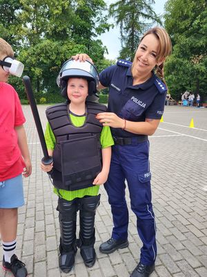 policjantka stoi z dzieckiem ubranym w kask