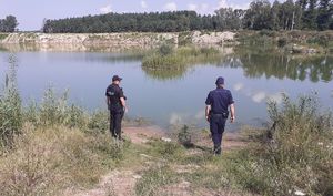 policjanci stoją na brzegu kąpieliska