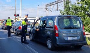 policjant kontroluje kierowcę przy zamkniętym szlabanie