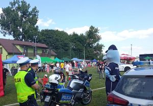 policjanci przy motocyklu i radiowozie w tle festyn