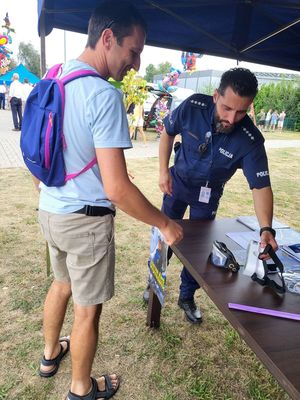 policjant rozmawia z uczestnikiem festynu