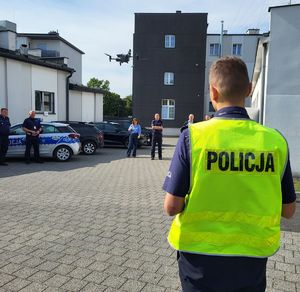 policjant pokazuje jak wznosi się dron