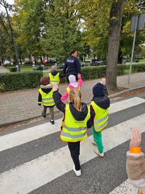 dzieci przechodzą przez pasy z policjantką