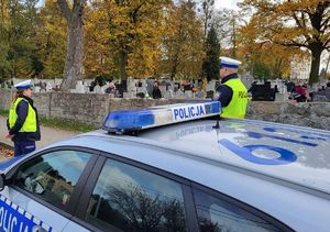 policjanci stoją przy cmentarzu