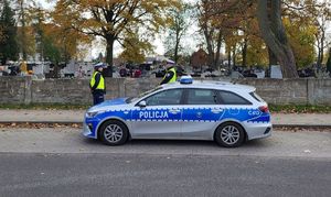 policjanci stoją przy cmentarzu