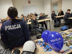 policjantka siedzi przed uczniami na sali