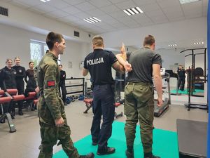 policjant pokazuje chwyt obezwładniający uczniowi