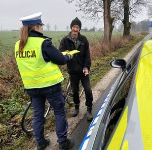 policjantka daje rowerzyście kamizelkę