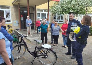 policjanci rozmawiają z seniorami na dworzu