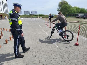policjant obserwuje jazdę rowerem jednego z uczniów