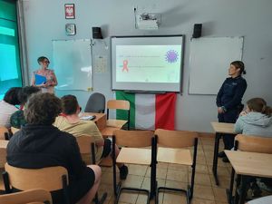 policjantka i pracownik sanepidu stoją przy tablicy interaktywnej