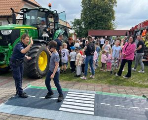policjantka z dzieckiem na macie drogowej