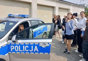 dziewczyna zasiada za kierownicą radiowozu