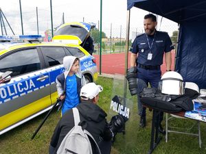 policjant stoi przy stoisku profilaktycznym