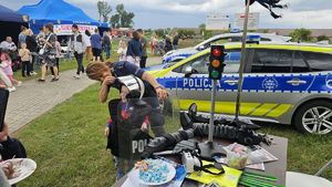 policjantka ubiera dziecko w policyjne wyposażenie