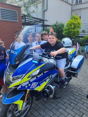 chłopiec siedzi na policyjnym motocyklu
