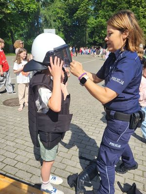 policjantka zakłada kask uczniowi