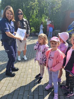 policjantka pokazuje dzieciom rysowanki