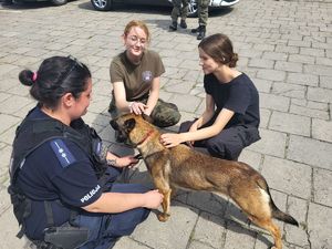 kobiety głaszczą psa służbowego