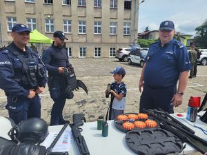 policjanci pokazują dziecku broń jaką wykorzystują