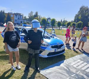 dzieci przy radiowozie , chłopiec we włożonym umundurowaniu