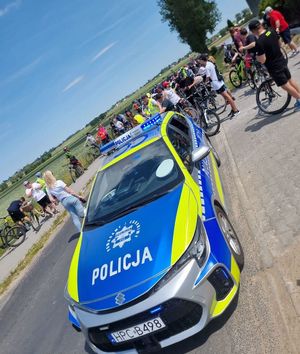 radiowóz za którym uczestnicy rajdu rowerowego