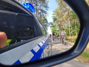 radiowóz z ujęciem jadacych cyklistów