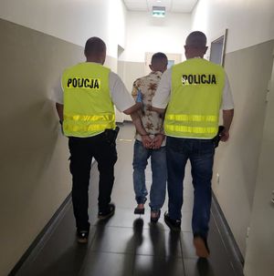 policjanci prowadzą zatrzymanego