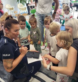 policjantka pobiera odcisk paluszka od dziecka