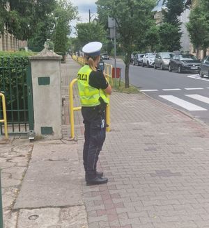 policjantka stoi przy przejściu dla pieszych z miernikiem prędkości