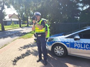 policjant mierzy prędkość na drodze