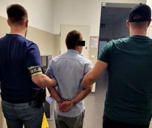 policjanci prowadzą zatrzymanego