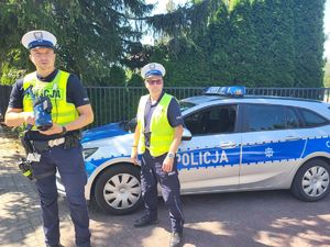 policjanci stoją przy radiowozie