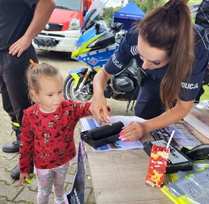 policjantka pobiera odcisk palca od dziecka