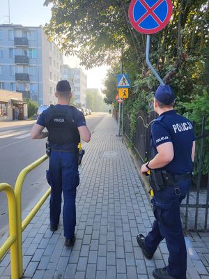 policjanci stoją na chodniku przy przejściu