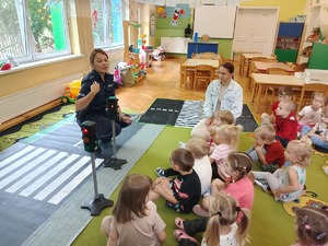 policjantka pokazuje dzieciom matę z pasami