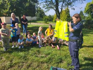 policjantka pokazuje kamizelkę odblaskową