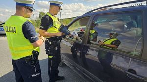 policjanci przekazują ulotkę kierowcy