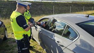 policjanci stoją przy kontrolowanym pojeździe
