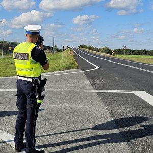 policjant mierzy prędkość na drodze