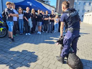 przewodnik z psem stoi przed uczniami