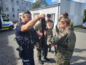 policjant pokazuje broń długą