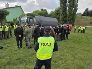 policjant stoi tyłem a w tle inni uczestnicy ćwiczeń