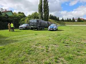 policjanci i strażacy stoją przy radiowozie